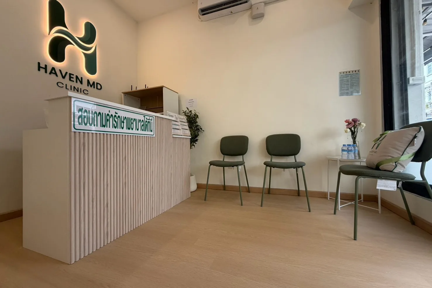 Haven MD Clinic 的前台，柜台上方是发光的诊所标识，旁边设有候诊座椅