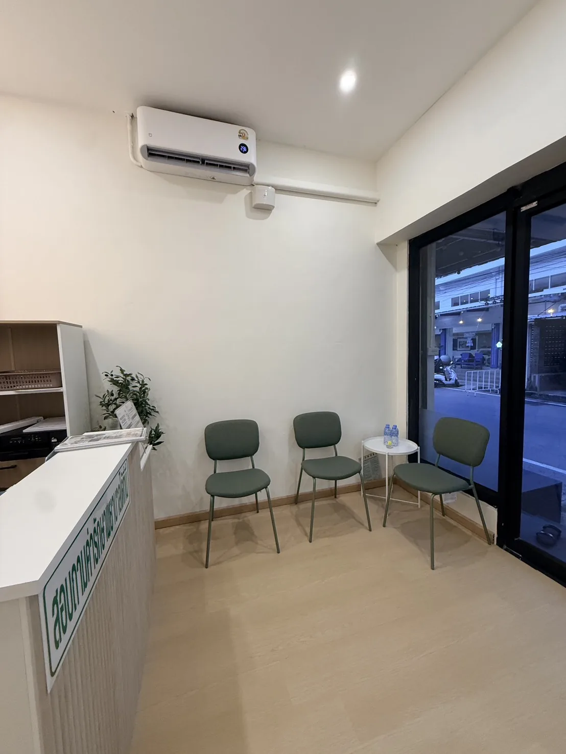 พื้นที่นั่งรอของ Haven MD Clinic มีเก้าอี้สามตัว โต๊ะข้าง และหน้าต่างที่มองออกไปยังถนน